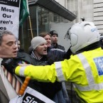 Aengus Ó Snodaigh is held back by a motorbike police at the gates at government buildings. 

(AP Photo/Peter Morrison)