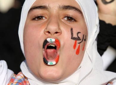 A girl with Syrian flag painted on her lips and Arabic writing that reads: