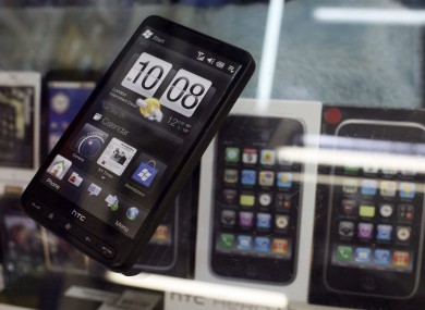 Taiwan's HTC mobile phones are seen on display near Apple Inc's iPhones in a popular computer market in Taipei