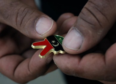 A Libyan man holds a souvenir of the Libyan revolution in the colors of the pre-Gadhafi flag.