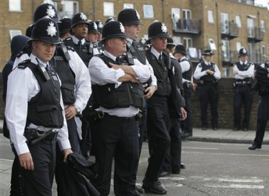British police officers stand on duty during the children day of Notting Hill Carnival in London, Sunday, Aug. 28, 2011.