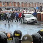 Nationalists in the Ardoyne area of Belfast try to set a car on fire during clashes with police (Photo: Laura Hutton/Photocall Ireland)