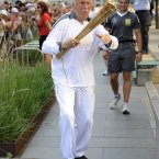 Torchbearer 131 Sir Bruce Forsyth carries the Olympic Flame on the Torch Relay leg through Kensington and Chelsea (Royal London Borough).