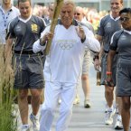 Torchbearer 131 Sir Bruce Forsyth carries the Olympic Flame on the Torch Relay leg through Kensington and Chelsea (Royal London Borough).