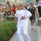 Torchbearer 131 Sir Bruce Forsyth carries the Olympic Flame on the Torch Relay leg through Kensington and Chelsea (Royal London Borough).