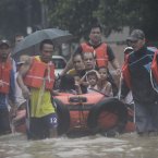 Stranded residents ride a rubber boat pulled by rescuers along a flooded area in suburban Marikina, east of Manila, Philippines.
(AP Photo/John Javellana)