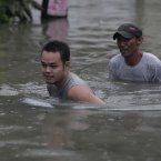 Filipino men cross deep floodwaters in suburban Quezon City, north of Manila, Philippines.
(AP Photo/Aaron Favila)
