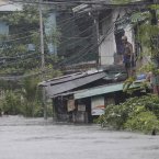 A man looks at the deep floodwaters outside his house in suburban Quezon City, north of Manila, Philippines today. Torrential rains pounding the Philippine capital paralysed traffic as waist-deep floods triggered evacuations of tens of thousands of residents and the government suspended work in offices and schools.(AP Photo/Aaron Favila)