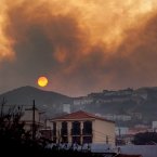 Smoke billows across houses as a wildfire burns near Chipude Village, La Gomera, Spain. Wildfires spurred by high temperatures raged across Spain's Canary Islands of La Gomera and Tenerife as well as Ourense in northwestern Spain. One firefighter died in a forest blaze.(AP Photo/Andres Gutierrez)