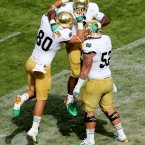 Notre Dame's running back Theo Riddick celebrates scoring the opening touchdown with Tyler Eifert and Braxston Cave.
©INPHO/James Crombie