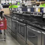 Tom Klitzke walks his pugs Max and Bear past home appliances at a Lowe's store in Omaha. (AP Photo/Nati Harnik)
