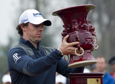 Rory McIlroy sets back his winner's trophy after winning his 18-hole medal-match against Tiger Woods in China.