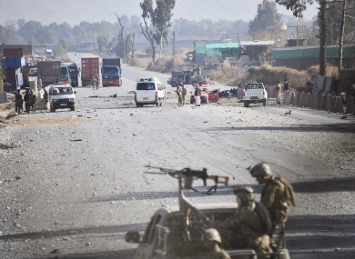 Afghan security forces block the road where Taliban suicide bombers attacked a joint U.S.- Afghan air base in Jalalabad.