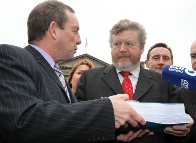 Health minister James Reilly receives the report of the Oireachtas Health committee on the proposed abortion laws, from its chairman Jerry Buttimer. Buttimer's committee will be called into action again to discuss the draft proposals.