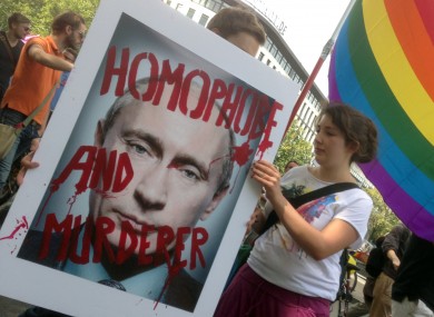 Demonstrators hold a poster with the portrait of Russian President Vladimir Putin during a protest march in Berlin, Germany this August.