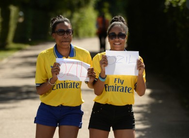 Arsenal fans Kimberley (left) and Yasmine Blackman show their support for Mesut Ozil outside Arsenal FC's London Colney training ground today.