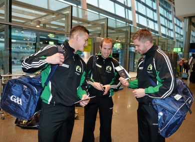 Lee Chin, Niall Kealy and Aidan Harte check their plane tickets in Dublin Airport.